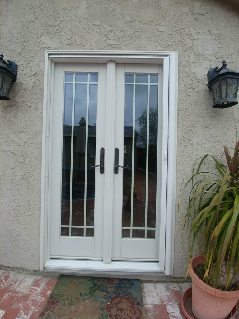 Retractable screen doors fitted to white French doors on an Orange County home
