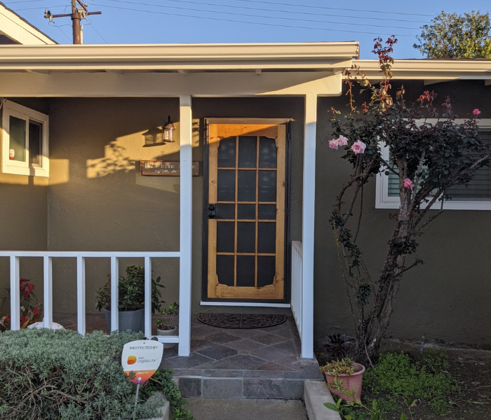 Swinging screen door on the front porch of an Orange County home at dusk